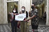 Perwakilan Asmen Kemitraan dan PKBL Perum LKBN ANTARA menyerahkan bantuan paket MCK  kepada Bupati Indramayu Nina Agustina (tengah) di kantor Bupati, Indramayu, Jawa Barat, Kamis (4/3/2021). Perum LKBN ANTARA memberikan bantuan berupa pembangunan fasilitas mandi, cuci, kakus (MCK) bagi masyarakat nelayan di desa tersebut. ANTARA JABAR/Dedhez Anggara/agr