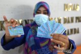 Petugas Dinas Kependudukan dan Pencatatan Sipil (Disdukcapil) Kota Banda Aceh memperlihatkan kartu tanda penduduk elektronik (e-KTP) di Banda Aceh, Aceh, Selasa (9/3/2021). Antara Aceh/Irwansyah Putra.