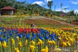 Pengunjung swafoto di Taman Kincir Jabal Nur, Desa Sukasetia, Kecamatan Cisayong, Kabupaten Tasikmalaya, Jawa Barat, Selasa (9/3/2021). Wisata taman kincir warna-warni yang berada di kaki Gunung Talaga Bodas tersebut memiliki 15.000 kincir angin yang menjadi spot foto favorit untuk wisatawan saat libur akhir pekan dan juga memiliki wahana lainnya seperti kolam renang, penginapan serta camping ground. ANTARA JABAR/Adeng Bustomi/agr
