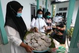Tenaga kesehatan Puskesmas Blang Bintang memasak kue tradisional apam sebagai upaya melestarikan warisan leluhur yang dilaksanakan setiap bulan Rajab di Aceh Besar, Aceh, Rabu (10/3/2021). Antara Aceh/Irwansyah Putra.