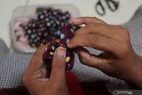 Pekerja membuat aksesoris busana wanita di Tiara Handicraft di Surabaya, Jawa Timur, Senin (8/3/2021). Tempat produksi berbagai produk kerajinan tekstil yang memberdayakan para difabel tersebut masih tetap bertahan ditengah pandemi COVID-19 dengan memanfaatkan media sosial maupun 'market place' untuk memasarkan produk-produknya. Antara Jatim/Didik Suhartono/zk