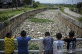 Sejumlah anak mengamati sampah yang menumpuk di Sungai Cikijing, Rancaekek, Kabupaten Bandung, Jawa Barat, Kamis (11/3/2021). Sampah yang menumpuk sepanjang 50 meter di sungai yang bermuara ke Sungai Citarum tersebut membuat bau yang tidak sedap serta warga berharap agar dinas terkait untuk membersihkan sampah yang berpotensi menimbulkan berbagai penyakit. ANTARA JABAR/Raisan Al Farisi/agr