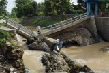 Warga melihat kondisi jembatan yang putus dan ambrol di kasawan Dam Piring Kota Madiun, Jawa Timur, Rabu (10/3/2021). Menurut warga jembatan serta bangunan dam tersebut putus dan ambrol pada Rabu (10/3) dini hari akibat banjir yang terjadi beberapa kali sebelumnya. Antara Jatim/Siswowidodo/zk