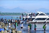 Sejumlah penumpang antre menaiki kapal cepat di kawasan Sanur, Denpasar, Bali, Sabtu (13/3/2021). Penyeberangan kapal cepat yang menghubungkan Sanur dengan sejumlah tujuan seperti Pulau Nusa Penida dan Nusa Lembongan tersebut dipadati oleh warga dan wisatawan menjelang penutupan operasional penyeberangan saat Hari Raya Nyepi tahun Saka 1943. ANTARA FOTO/Fikri Yusuf/nym.