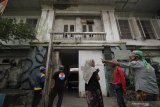 Warga mengamati bangunan bekas Penjara Kalisosok di Surabaya, Jawa Timur, Jumat (12/3/2021). Penjara Kalisosok yang merupakan bangunan cagar budaya itu kondisinya memprihatinkan dengan sejumlah bagian gedung yang rusak. Antara Jatim/Didik Suhartono/zk