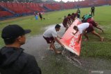 Pelatih Persik Kediri Joko Susilo (kiri) mengamati proses pengeringan lapangan menggunakan papan di Stadion Brawijaya, Kota Kediri, Jawa Timur, Selasa (16/3/2021). Stadion kandang Persik Kediri itu tergenang air usai hujan deras sehingga kurang layak untuk digunakan sebagai arena pertandingan. Antara Jatim/Prasetia Fauzani/zk