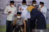 Wakil Gubernur Jawa Barat Uu Ruznahul Ulum (kiri) menyaksikan vaksinasi COVID-19 bagi para kyai dan ulama di Ponpes KHAS Kempek, Kabupaten Cirebon, Jawa Barat, Kamis (18/3/2021). Wagub Jawa Barat berharap vaksinasi untuk kyai dan ulama tidak mengalami keterlambatan. ANTARA JABAR/Dedhez Anggara/agr
