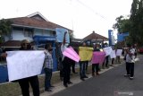 Sejumlah wartawan menggelar aksi solidaritas  kekerasan terhadap wartawan di Kantor UPT Dinas Kelautan dan Perikanan Jawa Timur, Banyuwangi, Jawa Timur, Kamis (18/3/2021). Aksi itu digelar sebagai bentuk keprihatinan atas aksi kekerasan oknum pengawal menteri Kelautan dan Perikanan kepada jurnalis saat melakukan tugas peliputan kunjungan kerja di Situbondo Selasa (16/3). Antara Jatim/Budi Candra Setya/zk