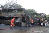 DUA BIS UMUM ANTAR PROVINSI HANGUS TERBAKAR. Petugas pemadam kebakaran menyemprotkan air untuk memadamkan sisa api saat kebakaran dua unit bis umum antar provinsi di Terminal Batoh, Banda Aceh, Aceh, Sabtu (20/3/2021). Tim Identifikasi Polresta Banda Aceh masih melakukan penyelidikan terkait penyebab kebakaran dua unit bis umum yang terparkir di terminal dan tidak ada korban jiwa dalam kejadian itu karena bis umum dalam kondisi tanpa penumpang. ANTARA FOTO/Ampelsa.