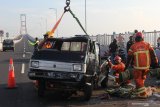 Petugas Rescue dari Dinas Pemadam Kebakaran Kota Surabaya mengevakuasi mobil yang mengalami kecelakaan di Jembatan Suramadu, Surabaya, Jawa Timur, Jumat (19/3/2021). Kecelakan mobil 'pick-up' bernopol L 8094 PF yang diduga menabrak pemisah jalan jembatan tersebut mengakibatkan satu penumpang meninggal dunia dan pengemudinya luka. Antara Jatim/Didik Suhartono/zk