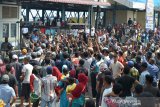Aksi Protes Pedagang dan Nelayan di Pelabuhan Perikanan Samudera. Pedagang ikan bersama buruh pelabuhan dan nelayan menggelar aksi protes penggusuran paksa disertai kekerasan yang dilakukan aparat keamanan di Pos Pelayanan Kesyahbandaran Pelabuhan Perikanan Samudera, Lampulo, Banda Aceh, Aceh, Senin (22/3/2021). Mereka menuntut pihak terkait memberikan izin untuk berjualan dan memberikan akses memasuki terminal pelabuhan mengangkut hasil tangkapan ikan menggunakan becak barang serta meminta pengamanan dan penertiban pelabuhan di bawah Lembaga Adat Laut. ANTARA FOTO/Ampelsa