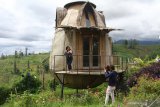 Wisatawan melakukan swafoto di depan rumah singgah yang dibentuk menyerupai kastil dalam film animasi Howl's Castle di Tempat Istirahat atau Rest Area Gubugklakah, Malang, Jawa Timur, Minggu (21/3/2021). Pemerintah setempat melengkapi rest area tersebut dengan berbagai fasilitas termasuk spot swafoto dan taman sebagai infrastruktur penunjang Kawasan Strategis Pariwisata Nasional (KSPN) Bromo Tengger Semeru. Antara Jatim/Ari Bowo Sucipto/zk