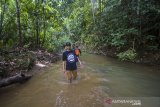 Wisatawan menyisir sungai saat menuju ke air terjun riam rampah tarawi di Kecamatan Hantakan, Kabupaten Hulu Sungai Tengah, Kalimantan Selatan, Selasa (23/3/2021). Kabupaten Hulu Sungai Tengah memiliki berbagai potensi daya tarik wisata salah satunya air terjun riam rampah terawi yang berada di dalam hutan Pegunungan Meratus yang menawarkan keindahan alam yang masih asri. Foto Antaranews Kalsel/Bayu Pratama S.