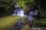 Wisatawan menikmati air terjun riam rampah tarawi di Kecamatan Hantakan, Kabupaten Hulu Sungai Tengah, Kalimantan Selatan, Selasa (23/3/2021). Kabupaten Hulu Sungai Tengah memiliki berbagai potensi daya tarik wisata salah satunya air terjun riam rampah terawi yang berada di dalam hutan Pegunungan Meratus yang menawarkan keindahan alam yang masih asri. Foto Antaranews Kalsel/Bayu Pratama S.