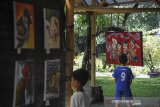 Sejumlah anak melihat karya seni lukisan yang dipamerkan di Saung Angklung Udjo, Bandung, Jawa Barat, Selasa (23/3/2021). Saung Angklung Udjo (SAU)menggelar pameran seni lukis dan fotografi dengan tema 