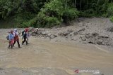 Sejumlah warga melintasi material lumpur akibat longsor di jalur alternatif Cijapati, Kadungora, Kabupaten Garut, Jawa Barat, Kamis (25/3/2021). Hujan deras disertai kondisi tanah yang gembur menjadi penyebab tanah longsor yang menutupi jalan penghubung antara Kabupaten Bandung dan Kabupaten Garut. ANTARA JABAR/Candra Yanuarsyah/agr
