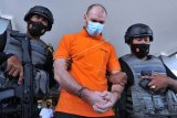 Warga negara Rusia Andrey Kovalenko alias Andrew Ayer (tengah) digiring petugas saat akan dideportasi di Kantor Imigrasi Kelas I Khusus TPI Ngurah Rai, Badung, Bali, Selasa (23/3/2021). Buronan Interpol terkait kasus narkotika jenis hashish seberat 146 kilogram pada tahun 2011 lalu di Rusia tersebut dideportasi ke negaranya setelah sebelumnya sempat melarikan diri dari Kantor Imigrasi Ngurah Rai pada bulan Februari 2021 saat proses administrasi pemindahannya ke Rumah Detensi Imigrasi Denpasar untuk menunggu pendeportasian usai menjalani hukuman pidana di Lapas Kerobokan karena kasus narkotika di Bali. ANTARA FOTO/Fikri Yusuf/aww.