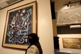 Pengunjung melihat lukisan koleksi musem Aceh yang ditampilkan pada pameran menyingkap pesan dalam goresan di Banda Aceh, Aceh, Rabu (24/3/2021). Pameran lukisan yang menampilkan 28 karya pelukis Aceh dan nasional tersebut dilaksanakan dengan protokol kesehatan COVID-19 dan iharapkan dapat memberikan pemahaman pada nilai keindahan serta memahami makna dari karya yang dipamerkan. Antara Aceh/Irwansyah Putra.