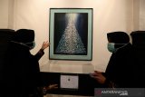 Pengunjung melihat lukisan koleksi musem Aceh yang ditampilkan pada pameran menyingkap pesan dalam goresan di Banda Aceh, Aceh, Rabu (24/3/2021). Pameran lukisan yang menampilkan 28 karya pelukis Aceh dan nasional tersebut dilaksanakan dengan protokol kesehatan COVID-19 dan iharapkan dapat memberikan pemahaman pada nilai keindahan serta memahami makna dari karya yang dipamerkan. Antara Aceh/Irwansyah Putra.