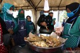 Warga mengikuti kelas memasak olahan berbahan ikan pada Fish Market Festival di Pelabuham Muncar, Banyuwangi, Jawa Timur, Kamis (25/3/2021). Festival pasar ikan yang menyuguhkan berbagai olahan, hasil tangkapan nelayan dan budidaya perikanan itu sebagai upaya mengangkat potensi perikanan di Banyuwangi. Antara Jatim/Budi Candra Setya/zk