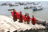 Penari menampilkan kreasi tari larung sesaji di tepi Pelabuham Satelit Muncar, Banyuwangi, Jawa Timur, Kamis (25/3/2021). Tarian yang ditampilkan oleh Padepokan Seni Dewi Sekartaji itu menceritakan nelayan muncar dalam melaksanakan tradisi petik laut sebagai warisan budaya leluhur. Antara Jatim/Budi Candra Setya/zk