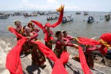 Penari menampilkan kreasi tari larung sesaji di tepi Pelabuham Satelit Muncar, Banyuwangi, Jawa Timur, Kamis (25/3/2021). Tarian yang ditampilkan oleh Padepokan Seni Dewi Sekartaji itu menceritakan nelayan muncar dalam melaksanakan tradisi petik laut sebagai warisan budaya leluhur. Antara Jatim/Budi Candra Setya/zk