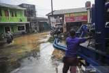 Petugas mengoperasikan alat pompa air di lokas banjir yang merendam kawasan Cingised, Bandung, Jawa Barat, Minggu (28/3/2021). Hujan dengan intensitas tinggi pada Sabtu (27/3) membuat kawasan tersebut terendam banjir luapan Sungai Cironggeng setinggi 30 hingga 60 sentimeter. ANTARA JABAR/Raisan Al Farisi/agr