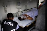 Personel Dokpol Polda Sulawesi Selatan membawa korban ledakan bom ke dalam mobil ambulans untuk dirujuk ke Rumah Sakit Bhayangkara di Makassar, Sulawesi Selatan, Minggu (28/3/2021). Korban luka ringan hingga berat akibat ledakan bom di Gereja Katedral Makassar bertambah menjadi 20 orang dan korban tewas berjumlah dua orang yang diduga pelaku bom bunuh diri. ANTARA FOTO/Arnas Padda/nym.