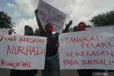 Sejumlah wartawan membentangkan poster saat melakukan aksi solidaritas di kawasan Monumen Arek Lancor, Pamekasan, Jawa Timur, Senin (29/3/2021). Mereka menuntut pihak berwajib untuk  mengusut tuntas oknum pelaku kekerasan terhadap wartawan Tempo, Nurhadi saat akan meminta konfirmasi kasus suap pajak. Antara Jatim/Saiful Bahri/zk