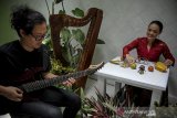 Seniman asal Bandung, Fransisca Agustina (kanan) memainkan instrumen musik melalui media buah dan sayuran saat pertunjukan musik eksperimental di garasi rumah, Andir, Bandung, Jawa Barat, Selasa (30/3/2021). Pertunjukan musik eksperimental yang menampilkan kolaborasi antara Fransisca Agustin dengan gitaris Hinhin Agung Daryana tersebut digelar dalam rangka persiapan gelaran Bandung Art Month serta memperkenalkan alat musik elektronik, etnik dan eksperimental. ANTARA JABAR/Raisan Al Farisi/agr