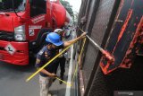 Petugas mengukur tinggi bak truk saat razia angkutan barang di Kota Kediri, Jawa Timur, Selasa (30/3/2021). Razia gabungan Dinas Perhubungan, Polisi, dan Polisi Militer tersebut menindak angkutan barang melebihi tonase yang dapat membahayakan pengguna jalan. Antara Jatim/Prasetia Fauzani/zk.