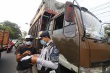 Petugas memeriksa surat kelengkapan kendaraan saat razia angkutan barang di Kota Kediri, Jawa Timur, Selasa (30/3/2021). Razia gabungan Dinas Perhubungan, Polisi, dan Polisi Militer tersebut menindak angkutan barang melebihi tonase yang dapat membahayakan pengguna jalan. Antara Jatim/Prasetia Fauzani/zk.