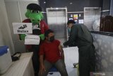 Maskot Persebaya Surabaya si Jojo (kiri) menyaksikan proses penyuntikan vaksin COVID-19 AstraZeneca saat vaksinasi massal di kampus Universitas Muhammadiyah Surabaya (UMS), di Surabaya, Jawa Timur, Selasa (30/3/2021). Vaksinasi massal di kampus UMS tersebut dalam rangka mensukseskan program vaksinasi COVID-19 nasional yang diikuti 588 dosen, karyawan dan warga Muhammadiyah yang ada di Surabaya. Antara Jatim/Moch Asim/zk.