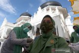 Warga mendapatkan suntikan vaksin COVID-19 di halaman Masjid Raya Baiturrahman, Banda Aceh, Aceh, Selasa (30/3/2021). Dinas Kesehatan Provinsi Aceh menargetkan tiga ribu warga termasuk anggota TNI/Polri, wartawan, atlet PON dan petugas pelayanan publik akan mendapatkan vaksin di halaman masjid tersebut. Antara Aceh/Irwansyah Putra