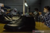 Pekerja menyelesaikan pembuatan Sepatu Kulit di Pabrik Fortuna Shoes, Bandung, Jawa Barat, Rabu (31/3/2021). Produk sepatu lokal yang terbuat dari kulit sapi, kuda dan buaya yang dijual kisaran harga Rp3 juta hingga Rp12 juta per pasang tersebut mampu bertahan di pasar ekspor hingga ke Jepang, Jerman, Belanda, Prancis meski mengalami penurunan akibat Pandemi COVID-19. ANTARA JABAR/Novrian Arbi/agr
