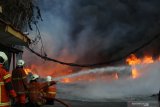 Petugas Dinas Pemadam Kebakaran Kota Surabaya memadamkan api yang membakar sebuah pabrik dan gudang palet plastik di kawasan Tandes, Surabaya, Jawa Timur, Rabu (31/3/2021). Puluhan kendaraan pemadam kebakaran dikerahkan untuk memadamkan kebakaran itu. Antara Jatim/Didik/Zk