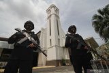 Dua anggota Brimob bersenjata lengkap dari Polda Jawa Timur berjaga di depan Gereja Katedral Hati Kudus Yesus di Surabaya, Jawa Timur, Jumat (2/4/2021). Penjagaan oleh sejumlah aparat dari TNI dan Polri tersebut guna menjamin keamanan bagi umat kristiani dalam melaksanakan ibadah Tri Hari Suci (Kamis Putih, Jumat Agung dan Minggu Paskah). Antara Jatim/Moch Asim/zk.