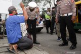 Petugas memeriksa warga yang melintas di jalan Raya Waru, Perbatasan Surabaya - Sidoarjo, Jawa Timur, Kamis (1/4/2021). Pemeriksaan dan penyekatan di titik perbatasan tersebut sebagai upaya meningkatkan pengamanan dan mengantisipasi ancaman teror. Antara Jatim/Umarul Faruq/zk.