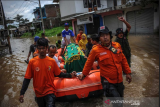 Petugas gabungan mengevakuasi jenazah menggunakan perahu karet di Andir, Baleendah, Kabupaten Bandung, Jawa Barat, Kamis (1/4/2021). Petugas gabungan dari BPBD, Pemadam Kebakaran, dan Tagana membantu mengevakuasi jenazah anggota keluarga yang meninggal dunia di permukiman yang terdampak banjir luapan Sungai Citarum. ANTARA FOTO/Raisan Al Farisi/aww. 