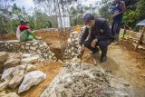 Ketua Ikatan Keluarga Alumni Lemhanas (IKAL) Kalsel Zulkifli (kanan) secara simbolis menyemen pondasi pembangunan langgar Darul Amin di Desa Haliau, Kabupaten Hulu Sungai Tengah, Kalimantan Selatan, Sabtu (3/4/2021). IKAL pusat yang di ketuai Agum Gumelar memberikan bantuan berupa peralatan rumah tangga seperti lemari dan kipas angin, dan bahan bangunan relokasi pembangunan langgar Darul Amin serta pembangunan empat unit rumah/hunian sementara untuk korban yang terdampak Banjir di Kalsel sebagai bentuk kepedulian atas bencana yang melanda sejumlah wilayah Indonesia. Foto Antaranews Kalsel/Bayu Pratama S.