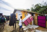 Warga menurunkan bantuan yang diberikan oleh Ikatan Keluarga Alumni Lemhanas (IKAL) kepada korban terdampak banjir bandang di Desa Waki, Kabupaten Hulu Sungai Tengah, Kalimantan Selatan, Sabtu (3/4/2021). IKAL pusat yang di ketuai Agum Gumelar memberikan bantuan berupa peralatan rumah tangga seperti lemari dan kipas angin, dan bahan bangunan relokasi pembangunan langgar Darul Amin serta pembangunan empat unit rumah/hunian sementara untuk korban yang terdampak Banjir di Kalsel sebagai bentuk kepedulian atas bencana yang melanda sejumlah wilayah Indonesia. Foto Antaranews Kalsel/Bayu Pratama S.