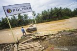 Warga berada di jembatan darurat yang putusi di Desa Waki, Kabupaten Hulu Sungai Tengah, Kalimantan Selatan, Minggu (4/4/2021). Jembatan darurat yang menghubungkan Desa Waki dengan desa seberang terputus akibat tingginya curah hujan pada kamis (1/4/2021) yang mengakibatkan derasnya arus sungai di desa tersebut. Foto Antaranews Kalsel/Bayu Pratama S.