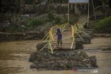 Warga berada di jembatan darurat yang putusi di Desa Waki, Kabupaten Hulu Sungai Tengah, Kalimantan Selatan, Minggu (4/4/2021). Jembatan darurat yang menghubungkan Desa Waki dengan desa seberang terputus akibat tingginya curah hujan pada kamis (1/4/2021) yang mengakibatkan derasnya arus sungai di desa tersebut. Foto Antaranews Kalsel/Bayu Pratama S.