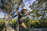 Seorang pengunjung berjalanan di fasilitas jembatan gantung di puncak wisata kampung bambu, Desa Tandilang, Kabupaten Hulu Sungai Tengah, Kalimantan Selatan, Minggu (4/4/2021).  Wisata alam yang di kelola oleh warga setempat tersebut menawarkan pemandangan Pegunungan Meratus serta menyediakan tempat berfoto dan camping ground untuk menjadi daya tarik wisatawan. Foto Antaranews Kalsel/Bayu Pratama S.