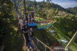 Sejumlah pengunjung menikmati pemandangan di puncak wisata kampung bambu, Desa Tandilang, Kabupaten Hulu Sungai Tengah, Kalimantan Selatan, Minggu (4/4/2021).  Wisata alam yang di kelola oleh warga setempat tersebut menawarkan pemandangan Pegunungan Meratus serta menyediakan tempat berfoto dan camping ground untuk menjadi daya tarik wisatawan. Foto Antaranews Kalsel/Bayu Pratama S.ANTARA FOTO (ANTARA FOTO)