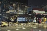 Sejumlah warga berada di dekat dinding bangunan yang ambruk di kawasan Pasar Ujung Murung di Jalan Sudimampir, Banjarmasin, Kalimantan Selatan, Senin (5/4/2021). Dinding di lantai tiga bangunan Pasar Ujung Murung ambruk mengakibatkan satu unit sepeda motor tertimpa reruntuhan bangunan. Foto Antaranews Kalsel/Bayu Pratama S.