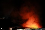  Petugas Dinas Pemadam Kebakaran  Kota Surabaya memadamkan api yang membakar sebuah pabrik di Jalan Tambak Osowilangun, Surabaya, Jawa Timur, Senin (5/4/2021) dini hari. Sebanyak 18 kendaraan pemadam kebakaran dikerahkan untuk memadamkan kebakaran pabrik yang memproduksi barang-barang dari plastik itu. Antara Jatim/Didik Suhartono/zk