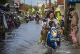 Pengendara motor melintasi banjir akibat luapan Sungai Martapura di Kelayan A, Banjarmasin, Kalimantan Selatan, Senin (5/4/2021). Hujan deras yang mengguyur sejumlah wilayah di Provinsi Kalimantan Selatan beberapa hari belakangan ini membuat kanal dan Sungai Martapura di Kota Banjarmasin meluap sehingga mengakibatkan sejumlah rumah dan jalan terendam banjir. Foto Antaranews Kalsel/Bayu Pratama S.