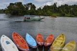 Wisatawan menggunakan perahu menuju Pulau Nusa Gede untuk berziarah di Situ Lengkong, Panjalu, Kabupaten Ciamis, Jawa Barat, Senin (5/4/2021). Situ Lengkong merupakan kawasan wisata religi atau wisata ziarah makam Prabu Hariang Kencana Borosngora atau Sayid Ali Bin Muhammad Bin Umar, dengan luas area sekitar 60 hektare. ANTARA JABAR/Adeng Bustomi/agr