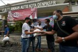 Relawan dari Let's Help Bali COVID-19 membagikan sembako kepada anak kembar penderita autisme, di Pusat Layanan Autis Kota Denpasar, Bali, Rabu (7/4/2021). Kegiatan yang merupakan rangkaian hari peduli autisme sedunia tersebut untuk membantu meringankan perekonomian keluarga dari anak penderita autisme di masa COVID-19. ANTARA FOTO/Nyoman Hendra Wibowo/nym.